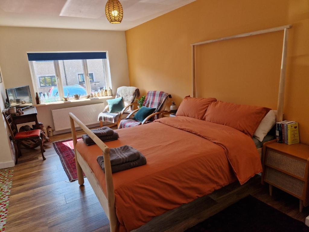 a bedroom with a bed with an orange blanket at Fairways in Melrose