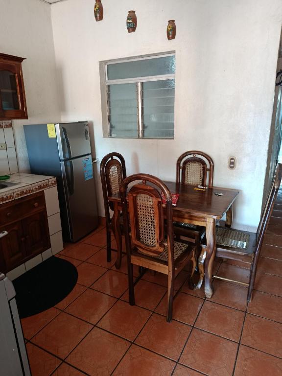 a kitchen with a table and chairs and a refrigerator at Hostal Expansion in San Juan del Sur