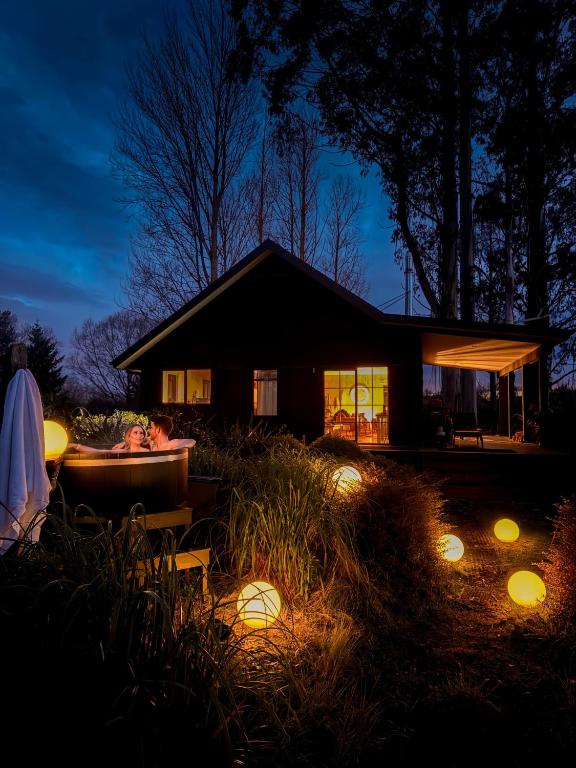 a house with a tub in the yard at night at Fiery Peak Eco-Retreat with Stargazing & Hot tub in Geraldine
