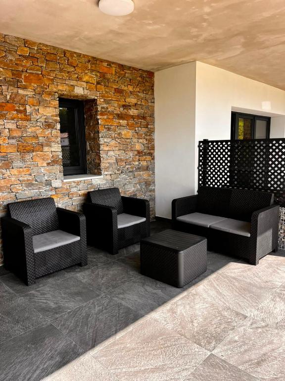 a lobby with two chairs and a brick wall at La Muraza in Villaviciosa