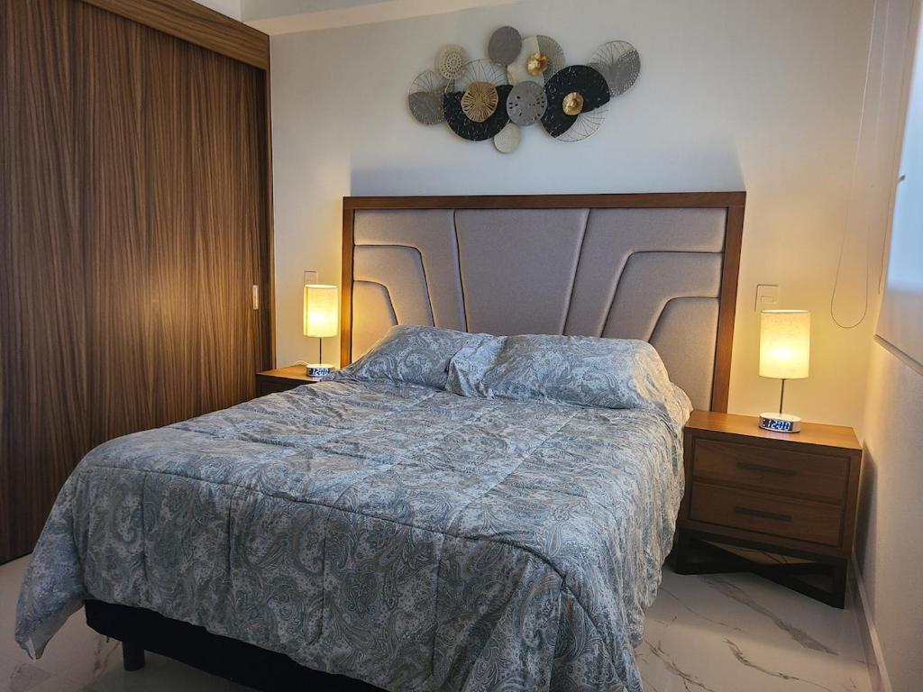 a bedroom with a bed and two night stands with lamps at Nuevo Vallarta Peaceful Loft in Nuevo Vallarta
