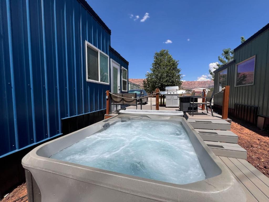 a jacuzzi tub sitting outside of a house at Tiny Home with Private Hot Tub, Zion Adventure Base in Apple Valley