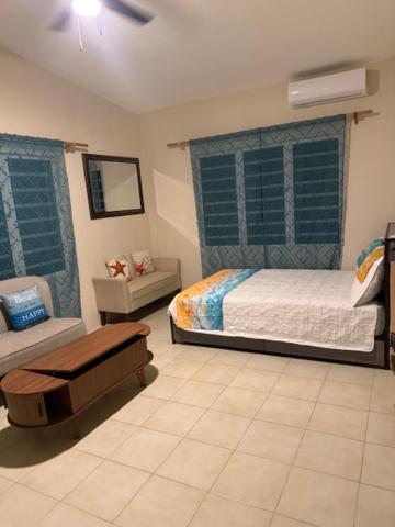 a bedroom with a bed and a chair in it at Peaceful Studio Retreat Near Shoal Bay Beach in Shoal Bay Village