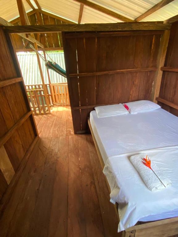 a bedroom with a white bed with a flower on it at Cumbilinchero Selva Mojada in Nuquí