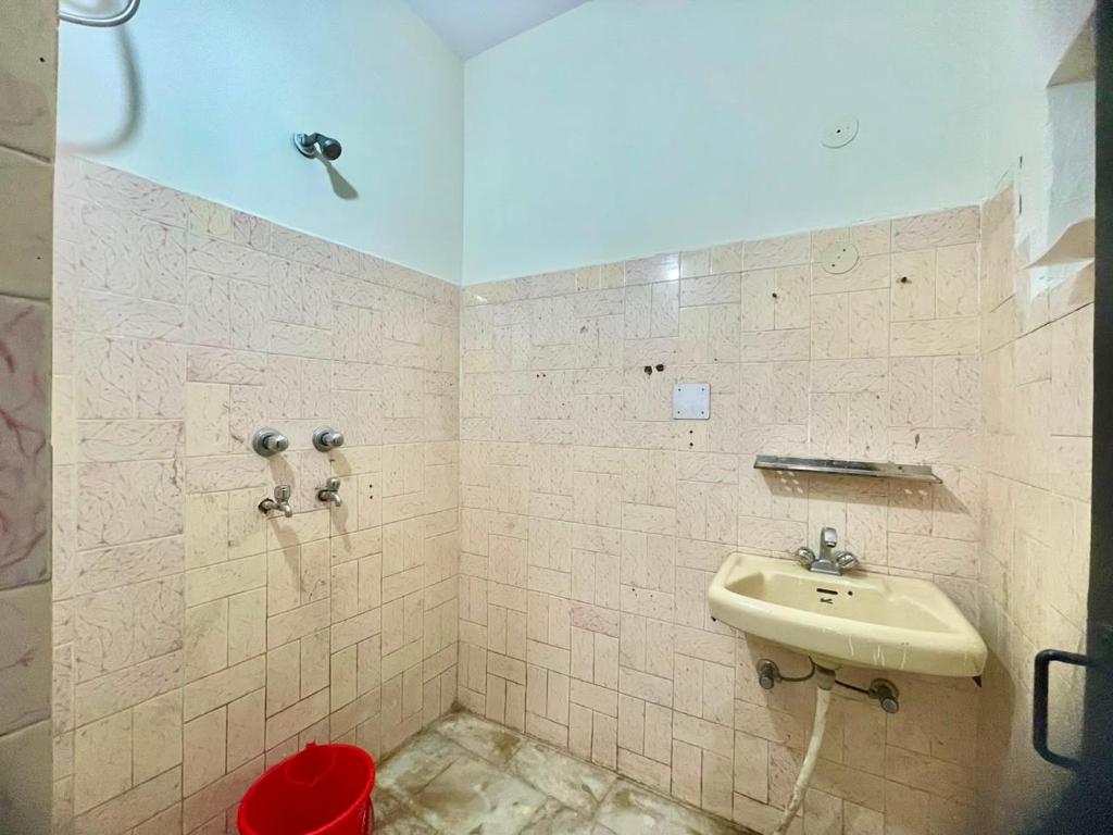 a bathroom with a sink and a red trash can at Land Chaster Kasauli in Kasauli