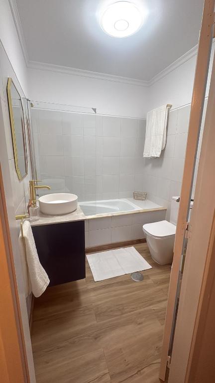 a bathroom with a tub and a sink and a toilet at T2 central Valença in Valença