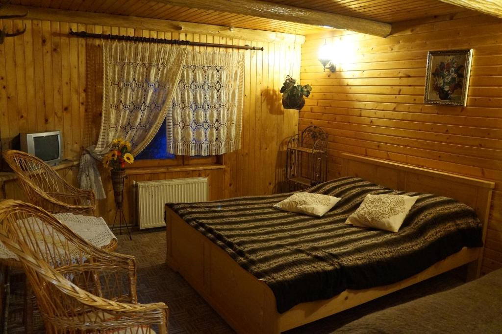 ヤレムチャにあるAt Starunchakiv familyの木製の部屋にベッド1台が備わるベッドルーム1室があります。