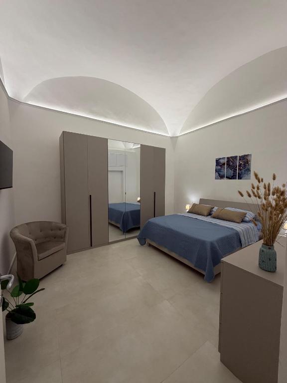 a bedroom with a blue bed and a chair at Sorrento Gem House in Meta
