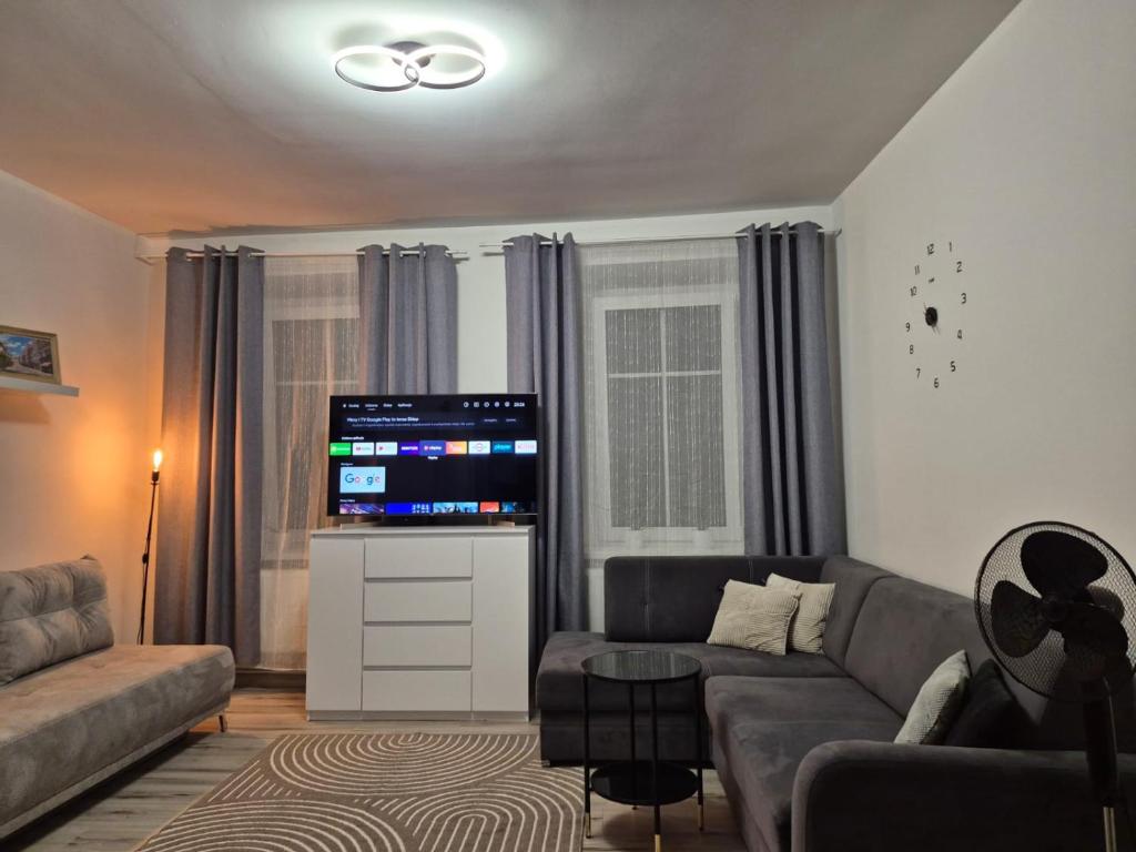 a living room with a couch and a flat screen tv at Noclegi Piastów 25 in Nowa Ruda