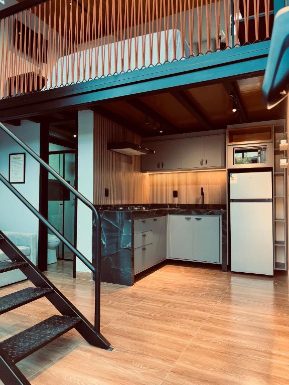 a kitchen with a staircase leading up to a loft at Villa Royal in Imperatriz
