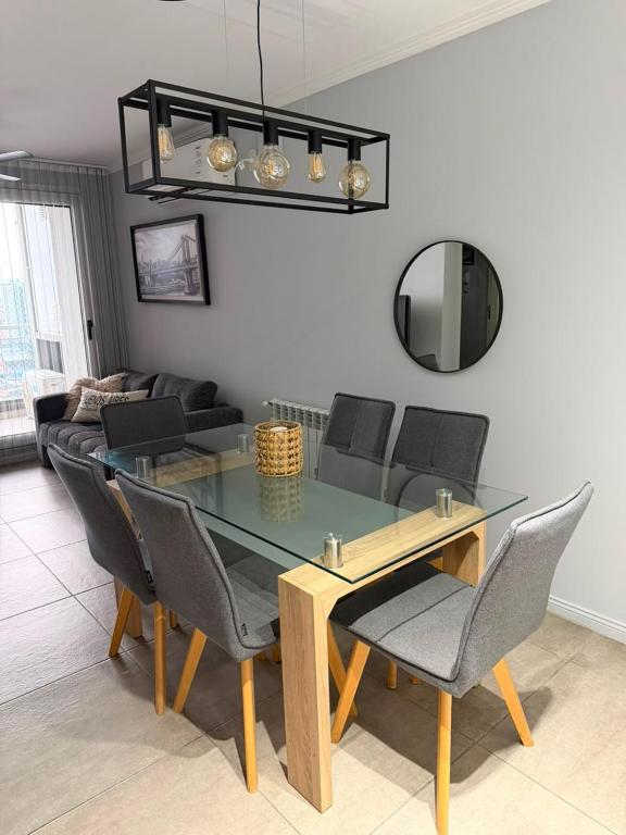 a dining room with a glass table and chairs at Departamento Rivadavia in Santa Fe