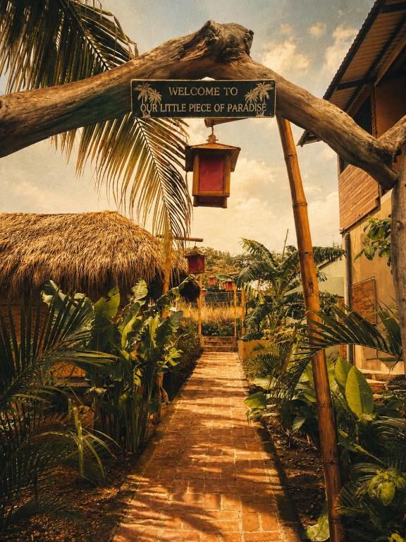 a sign that says welcome to the little tribe of paradise at Tipsy Gypsy Bar & Hotel in Tola