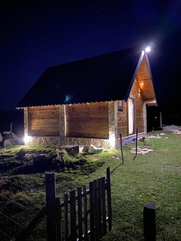 a wooden cabin with a light on the roof at night at Javorje Eco Cabin in Kolašin