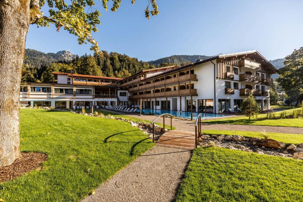 a large building with a tree in the foreground at Das Bayrischzell Familotel Oberbayern in Bayrischzell