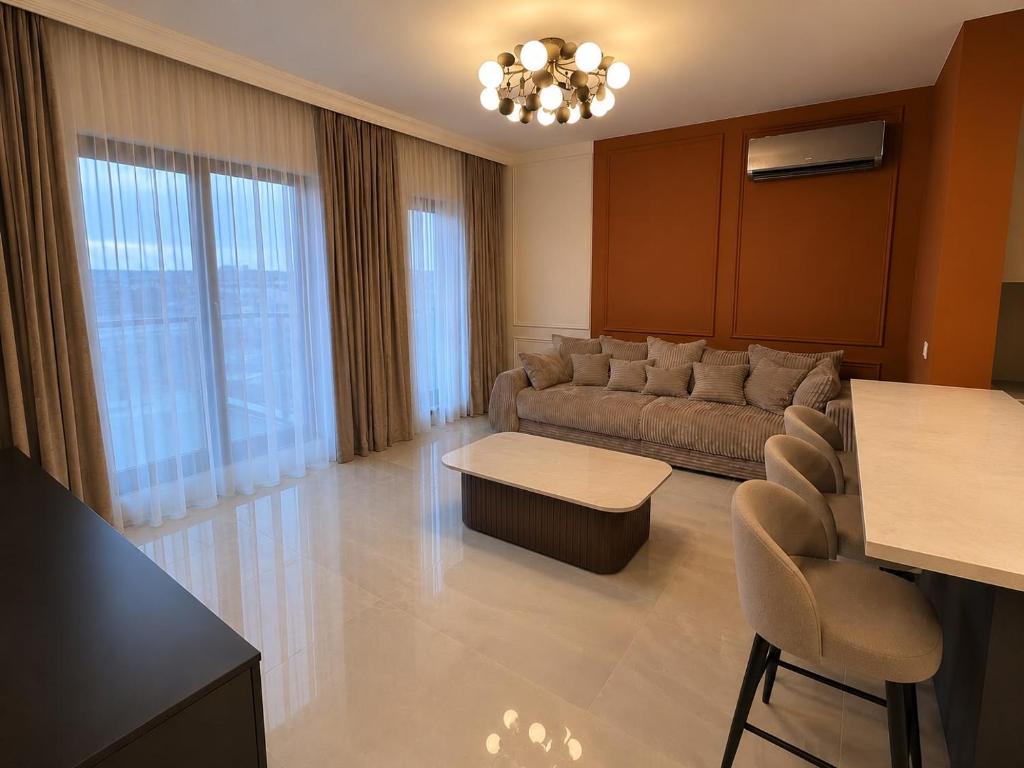 a living room with a couch and a table and chairs at Golden Sky Residence in Satu Mare