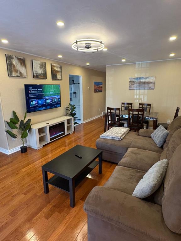 a living room with a couch and a tv at Tamuna's Home in Hamilton