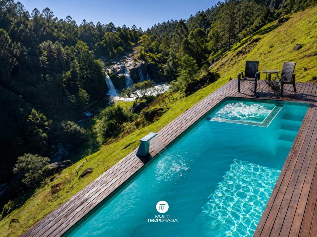 an overhead view of a pool on a hill with a waterfall at Pousada Dona Teresinha com Piscina Aquecida - São Bonifácio/SC in São Bonifácio