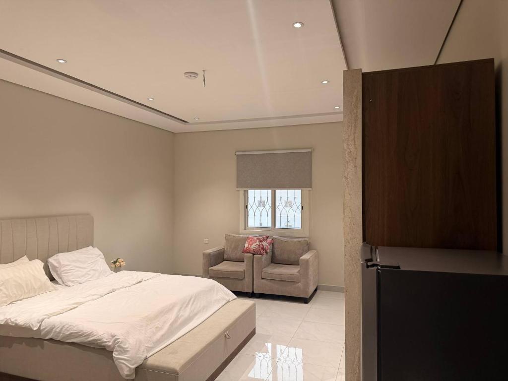 a bedroom with a bed and a chair and a window at Apartment in As Salam Rd in Medina