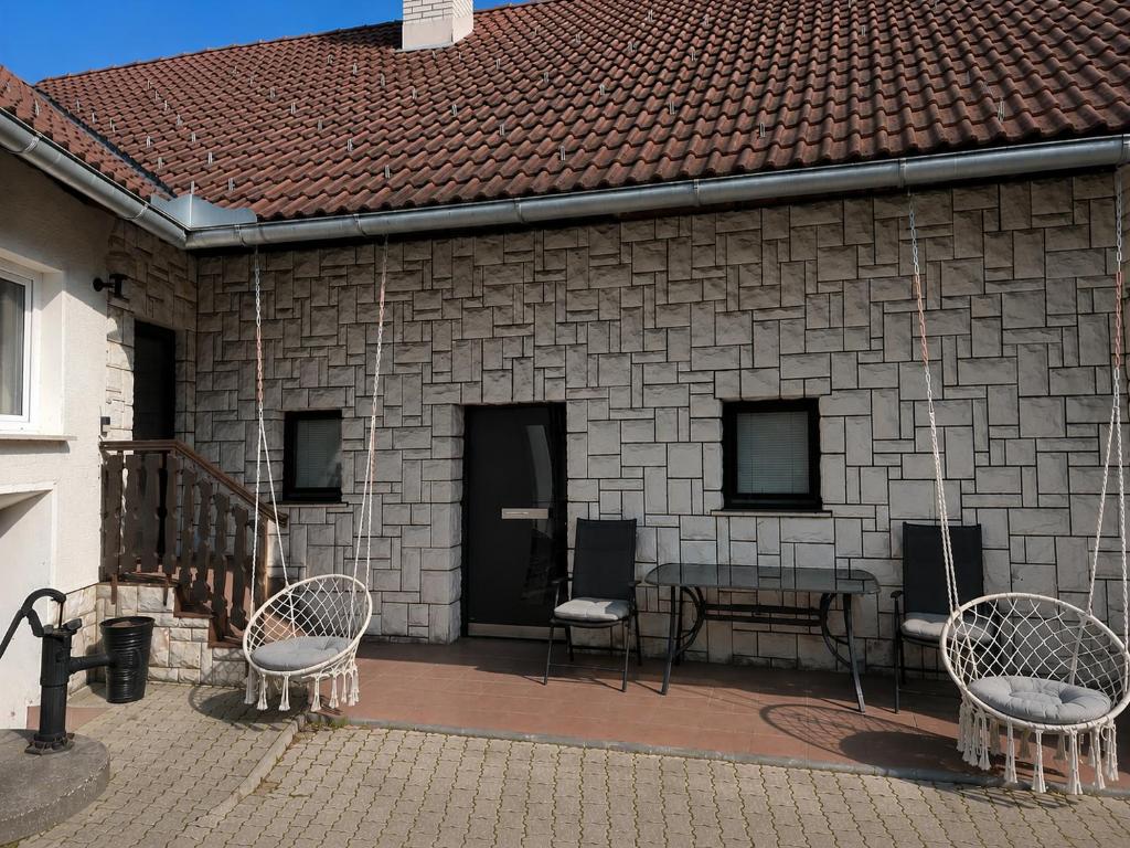 a patio with two chairs and a table and a building at Lusana in Moravske-Toplice