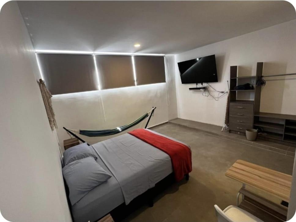 ein Schlafzimmer mit Bett und Flachbildfernseher in der Unterkunft Habitación en Iker's House in Mérida