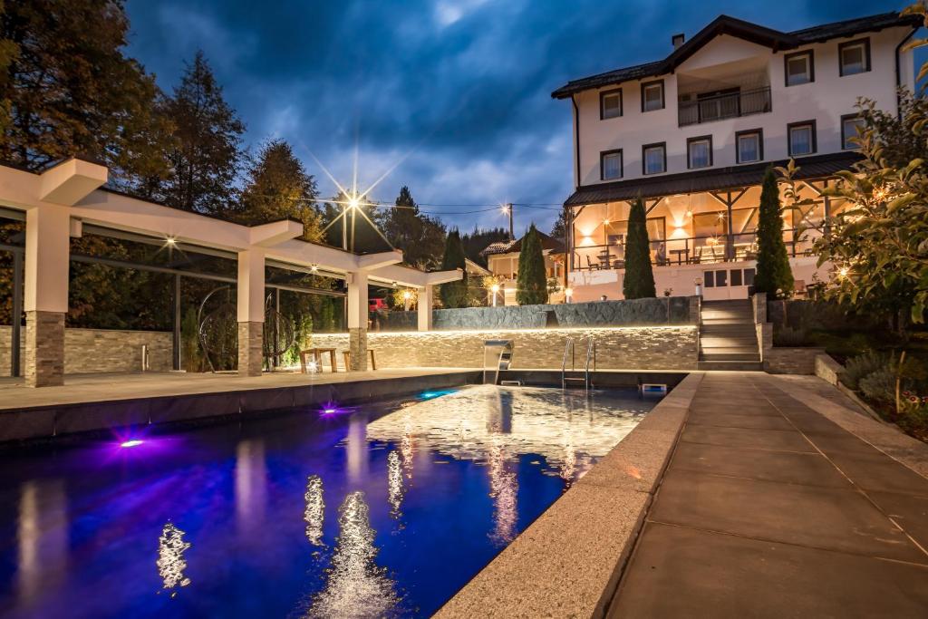 a house with a swimming pool in front of a building at Nature Bliss Villa in Sarajevo