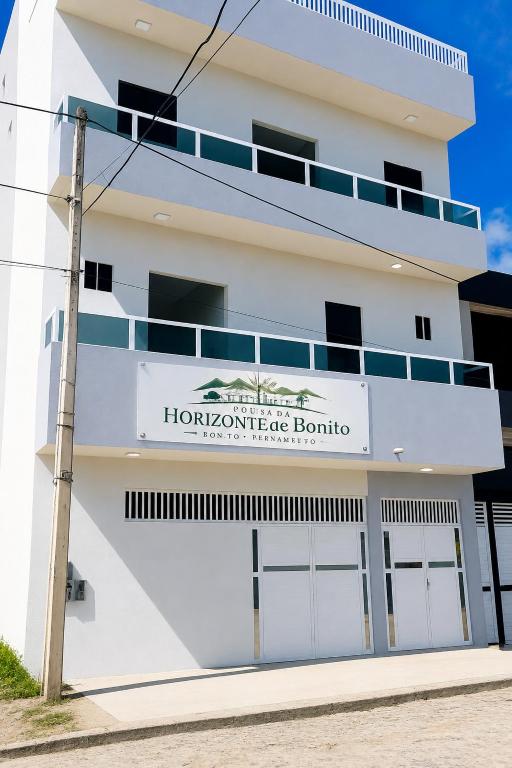 a white building with a sign that reads i homesteadride boutique at Pousada Horizontes de Bonito in Bonito