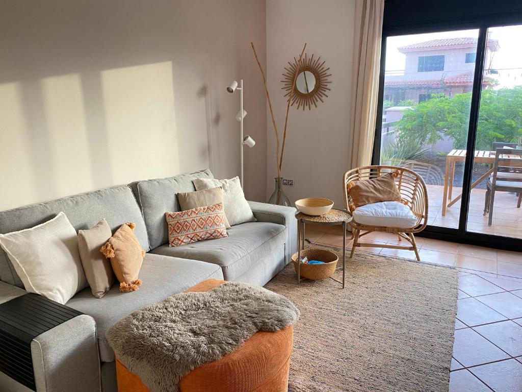 a living room with a gray couch with pillows at Mi Casa in Majanicho