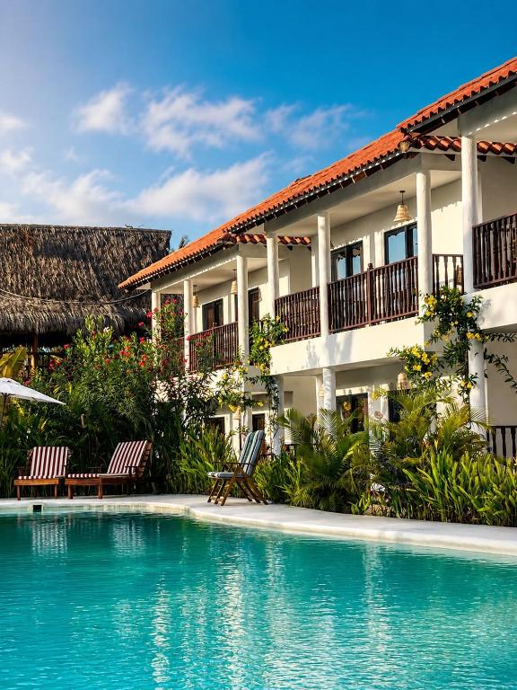 a hotel with a swimming pool in front of a building at Hotel Villa Toti in Santa Verónica