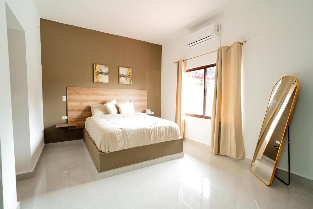 a bedroom with a bed and a mirror and a window at La Palma Experience in Panama City