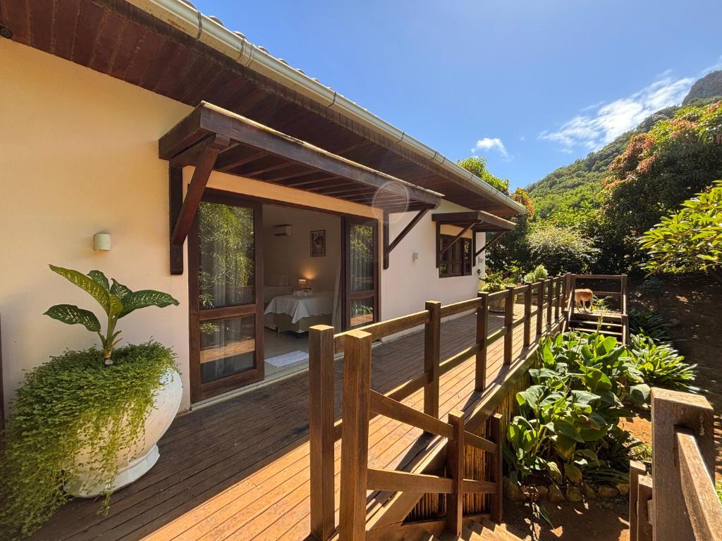 a house with a wooden deck with a balcony at Suites Amma Noronha in Fernando de Noronha