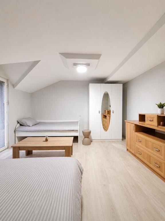 a white bedroom with two beds and a table at Villa Risteski Ohrid in Ohrid