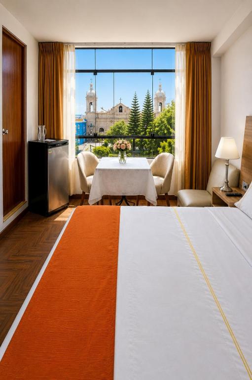 a hotel room with a bed and a table with a view at Hotel Plaza San Antonio Arequipa in Arequipa