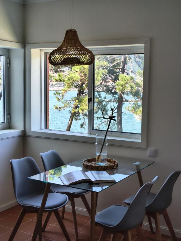 ein Esszimmer mit Tisch und Stühlen und einem Fenster in der Unterkunft Cabedelo River Flat in Darque