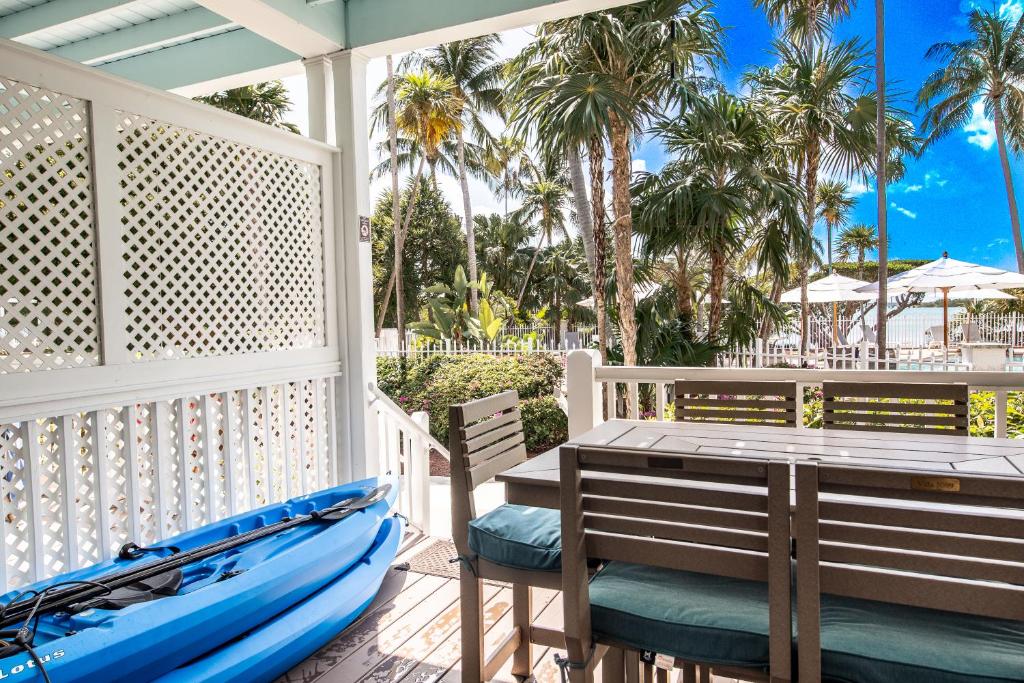 a kayak on a porch with a table and chairs at Crystal Waters - 2BR 2-5BA Coastal Villa in Duck Key