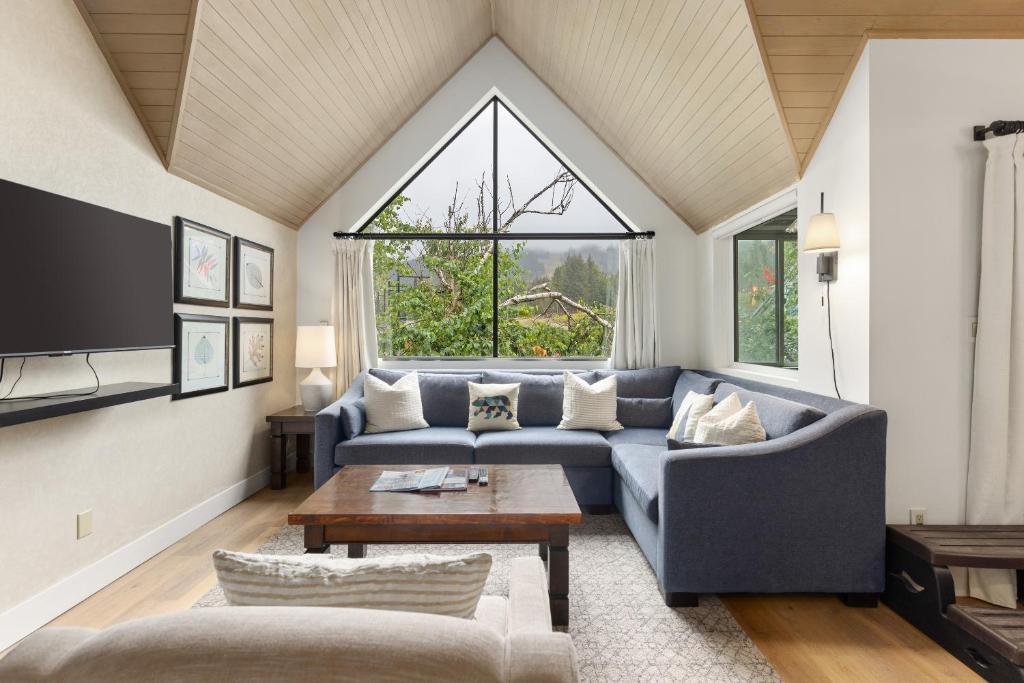 a living room with a blue couch and a table at Powder's Edge by Whiski Jack in Whistler