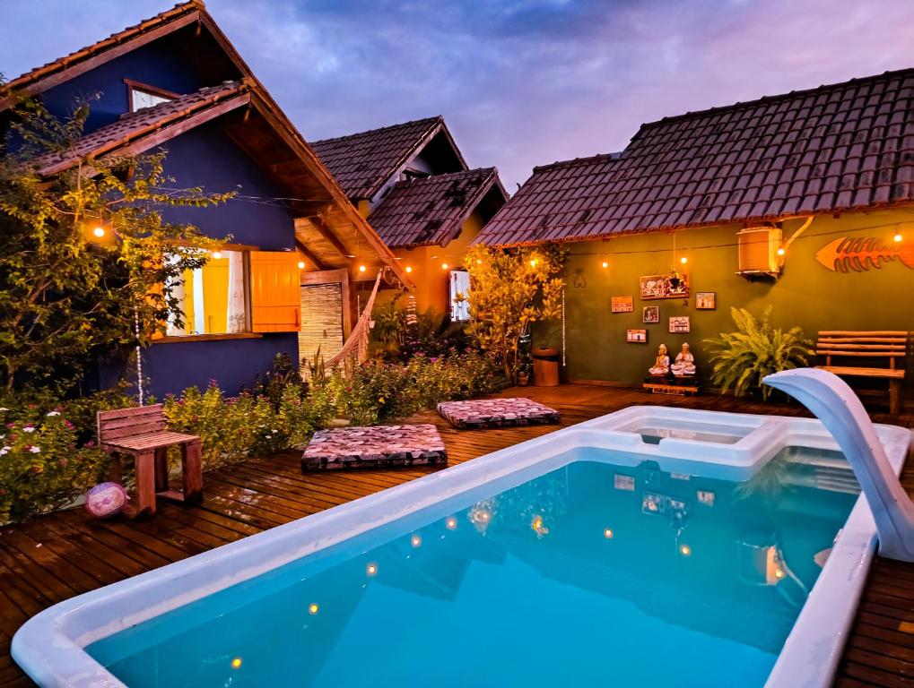 a backyard with a swimming pool and a house at Chalés Cabocla da Lua in Caraíva