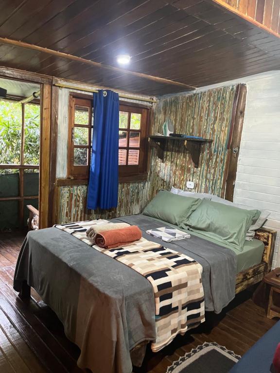 a bedroom with a bed in a room at Chalé Bambu in Cunha