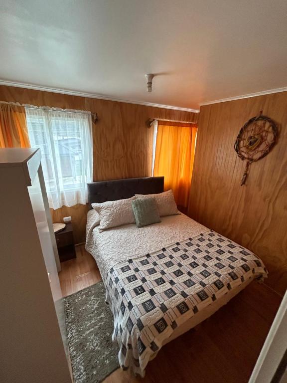 a small bedroom with a bed in a room at Ruta Pata Austral in Puerto Varas