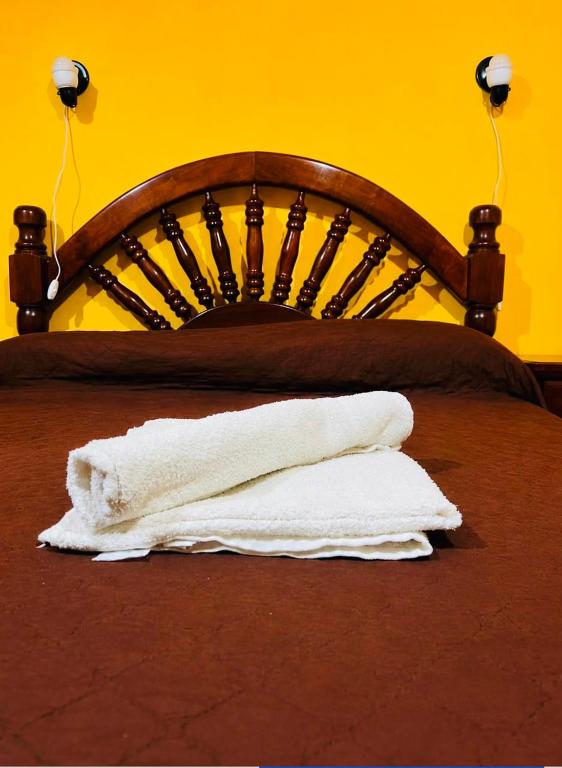 a pile of white towels sitting on a bed at Hotel el Progreso in Olta