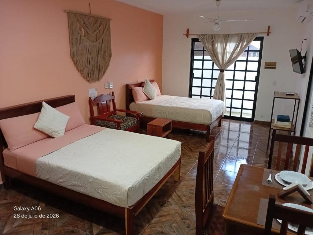 a room with two beds and a table and a dining room at Secret Paradise Mahahual in Mahahual