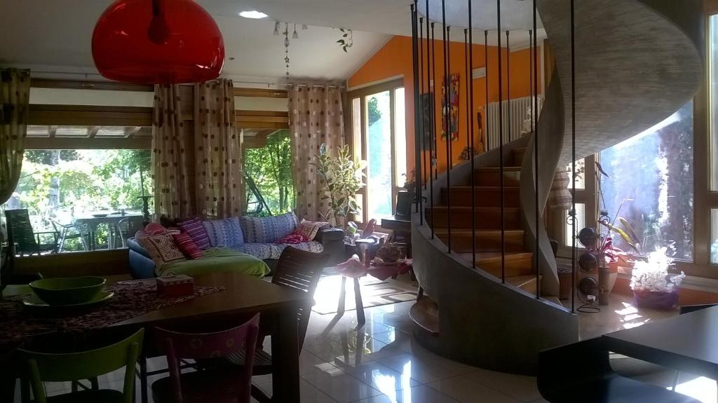 a living room with a staircase in the middle of a room at La Luce della Luna in Castelnovo Bariano