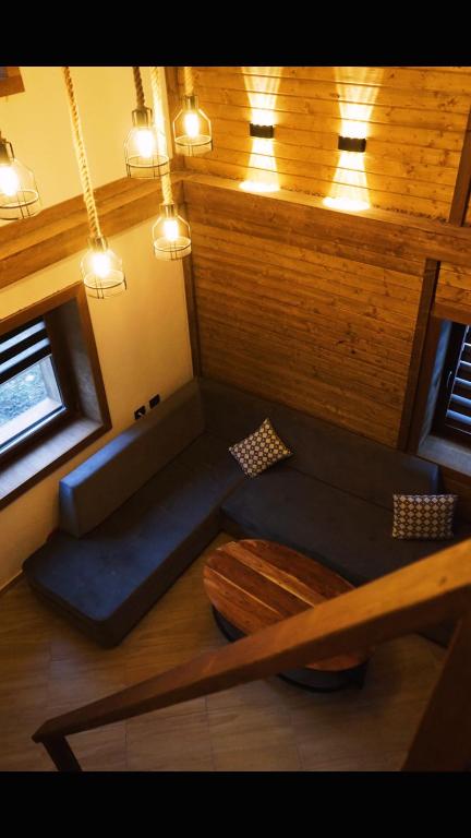 a living room with a blue couch and a window at Korja Apartments Mavrovo in Mavrovo