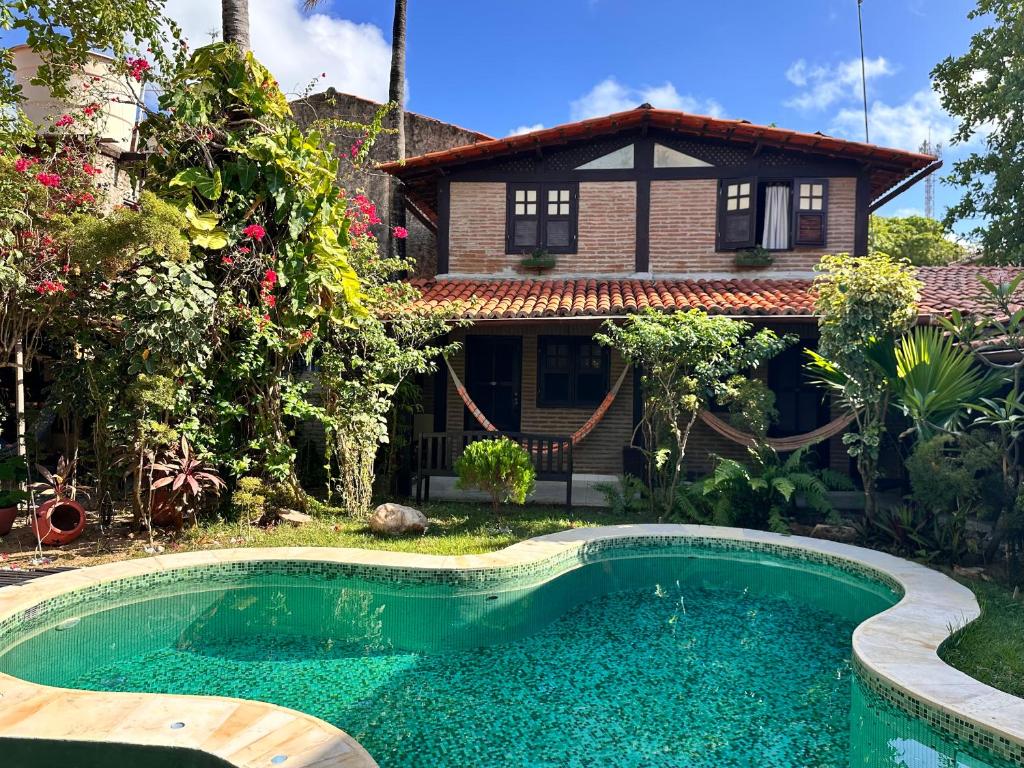 a house with a swimming pool in front of a house at Pousada Ibirapuera in Jericoacoara