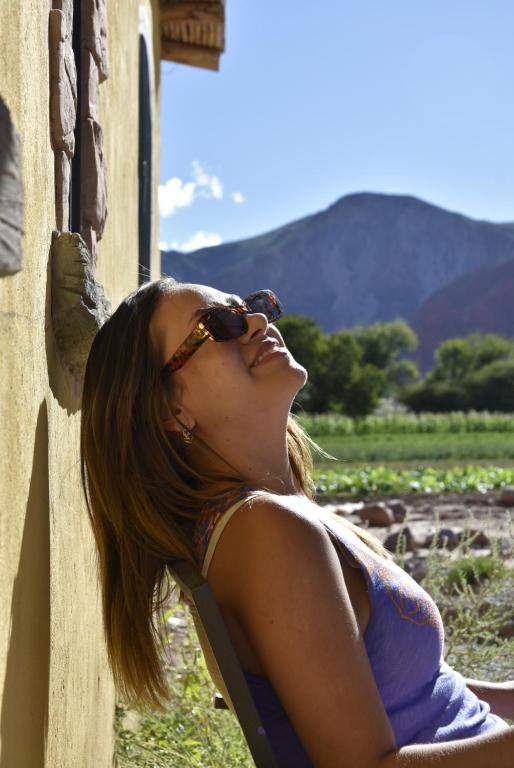 a woman leaning against a wall looking up at the sky at Cabañas Rurales HLS in Senador Pérez