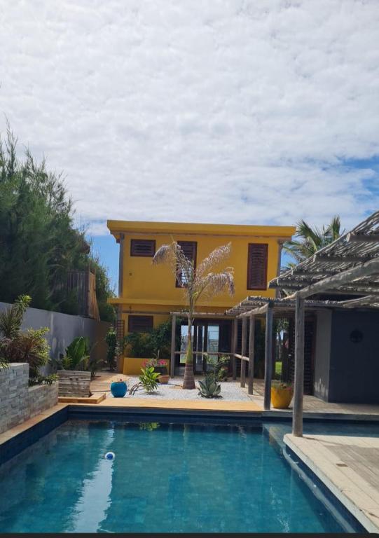 a house with a swimming pool in front of a house at Casa Bea in Fortim