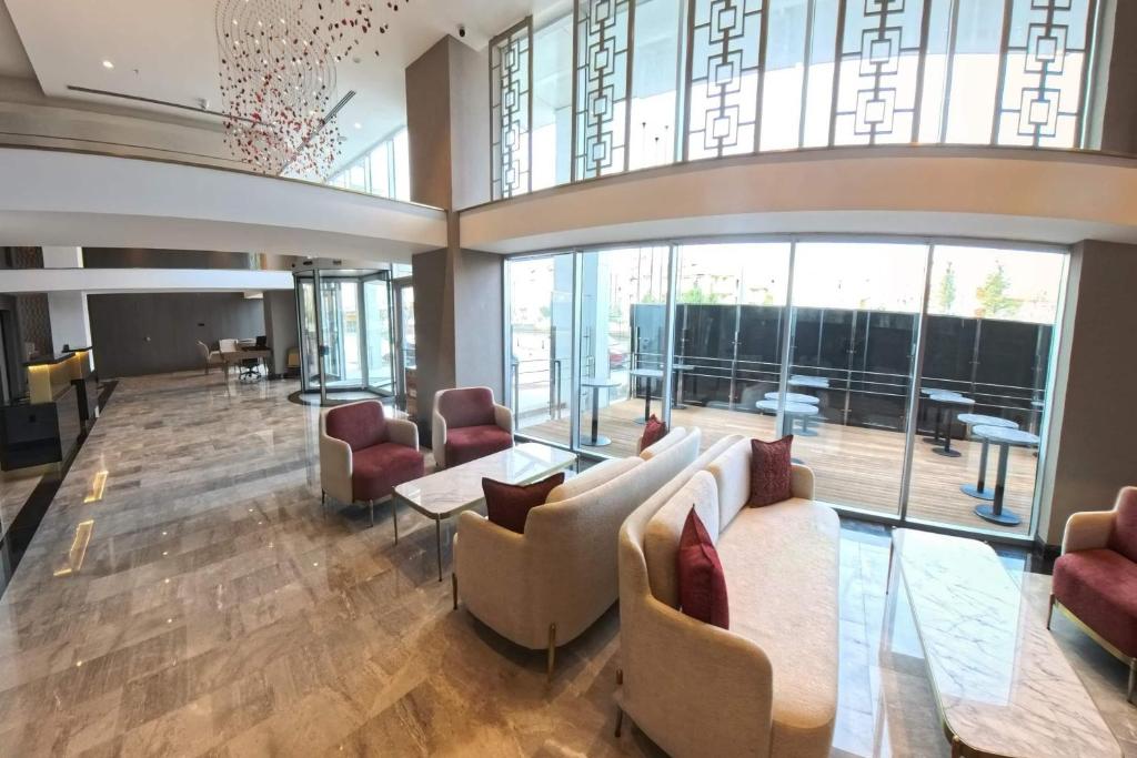 a lobby with couches and chairs and windows at Ramada Encore by Wyndham Konya Selcuklu in Konya