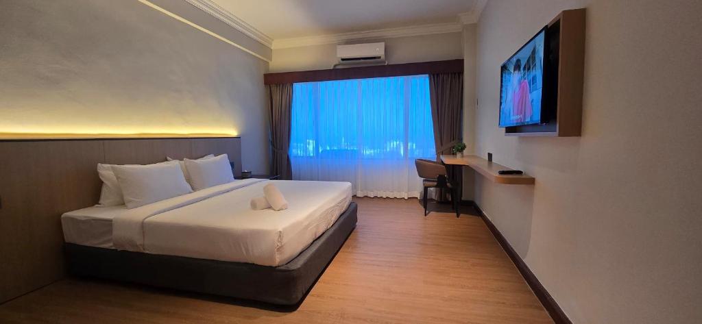 ein Hotelzimmer mit einem Bett und einem Fenster in der Unterkunft Kingston Hotel 28 - Gocos Hotel Klang in Klang