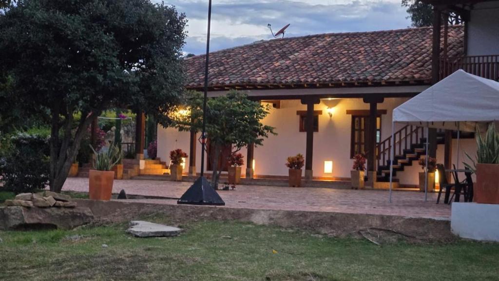 a building with a porch and a white tent at Hotel La Villa de Victoria Villa de Leyva in Sáchica
