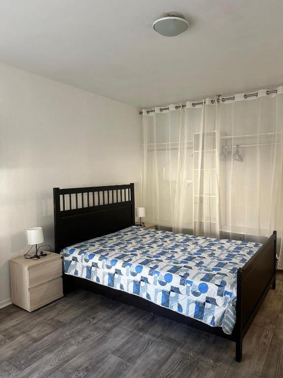 a bedroom with a bed and a nightstand with a bed sidx sidx sidx sidx at KIEVAILLE in Plaisir
