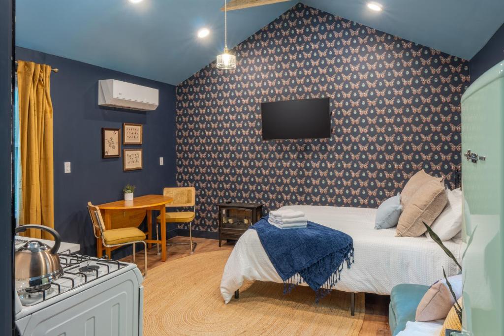 a bedroom with a bed and a tv on a wall at Soft Launch Deal Butterfly Bungalow Studio in Saugerties